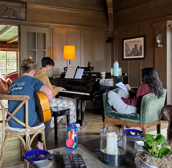 Students playing piano and guitar together in the lodge